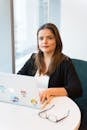 Confident businesswoman using laptop for remote work in a stylish office setting.